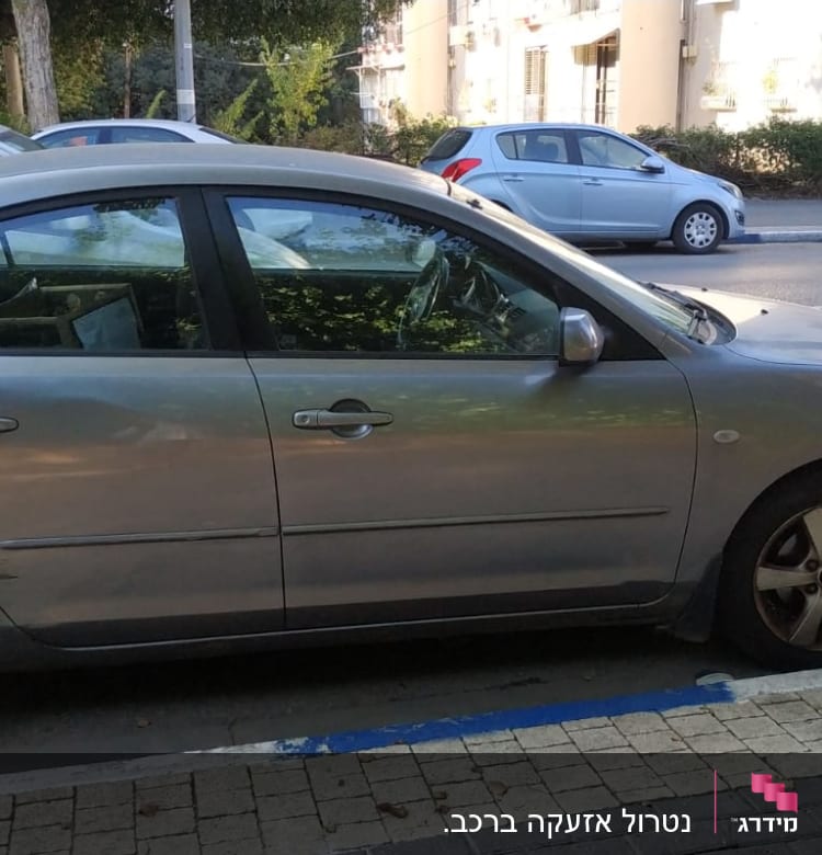 מכונית חונה בצד הדרך עם סימני נזק בצד